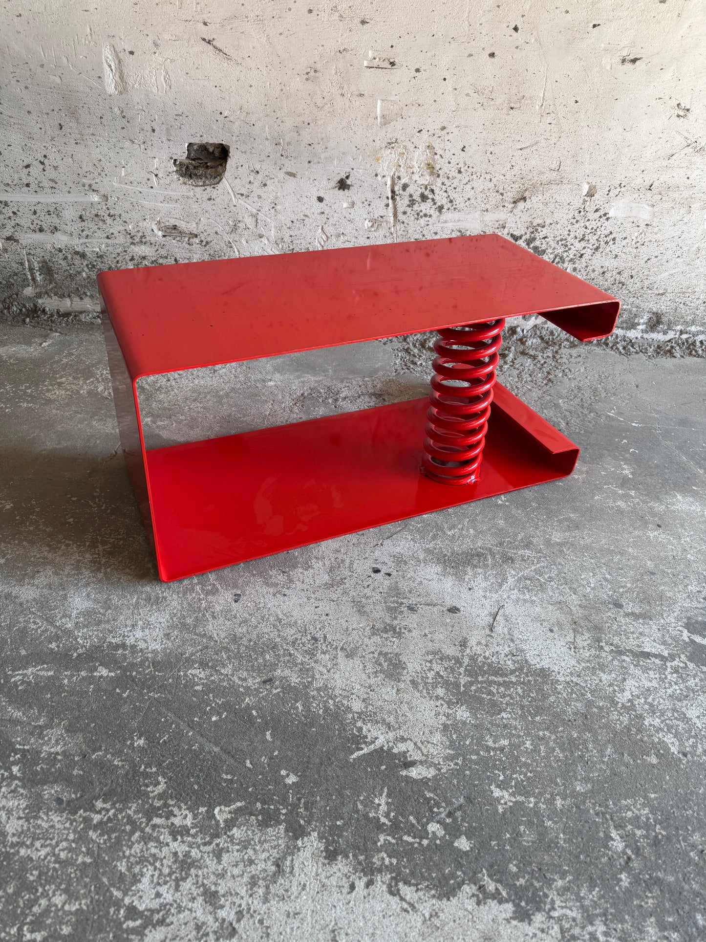 Table basse unique en acier laqué rouge avec ressort