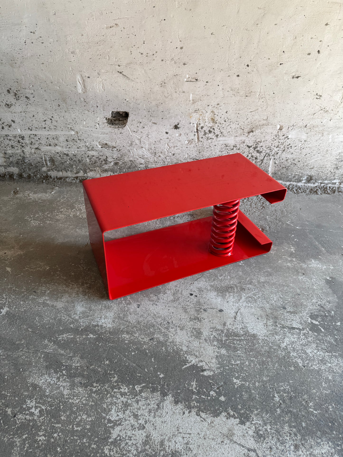 Table basse unique en acier laqué rouge avec ressort