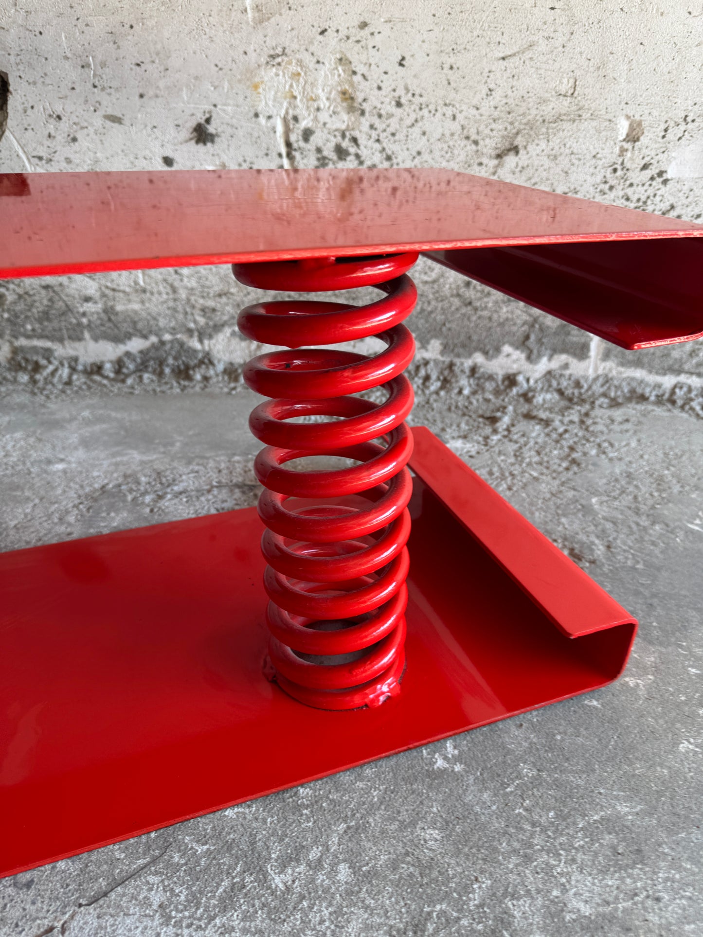 Table basse unique en acier laqué rouge avec ressort