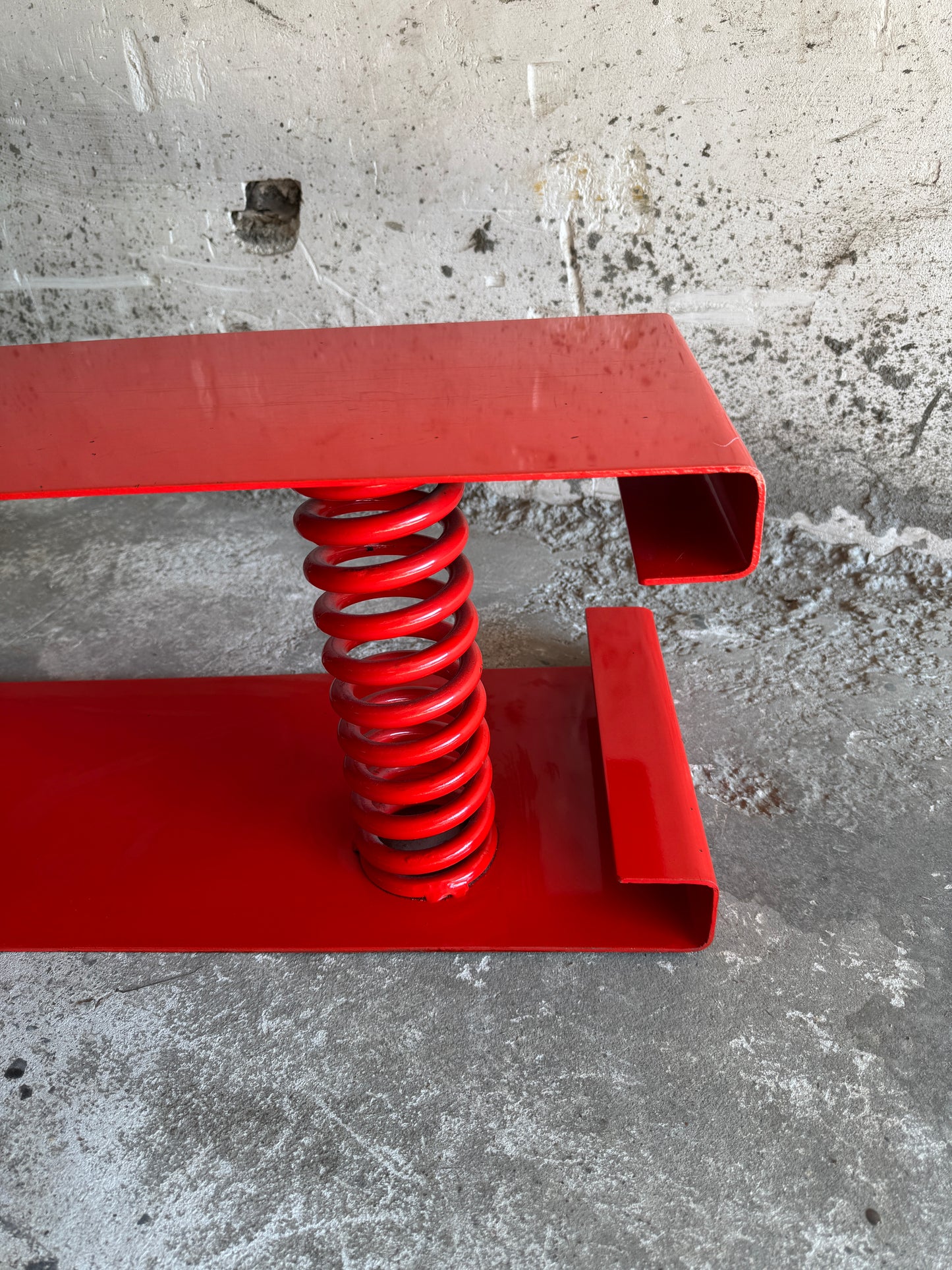 Table basse unique en acier laqué rouge avec ressort