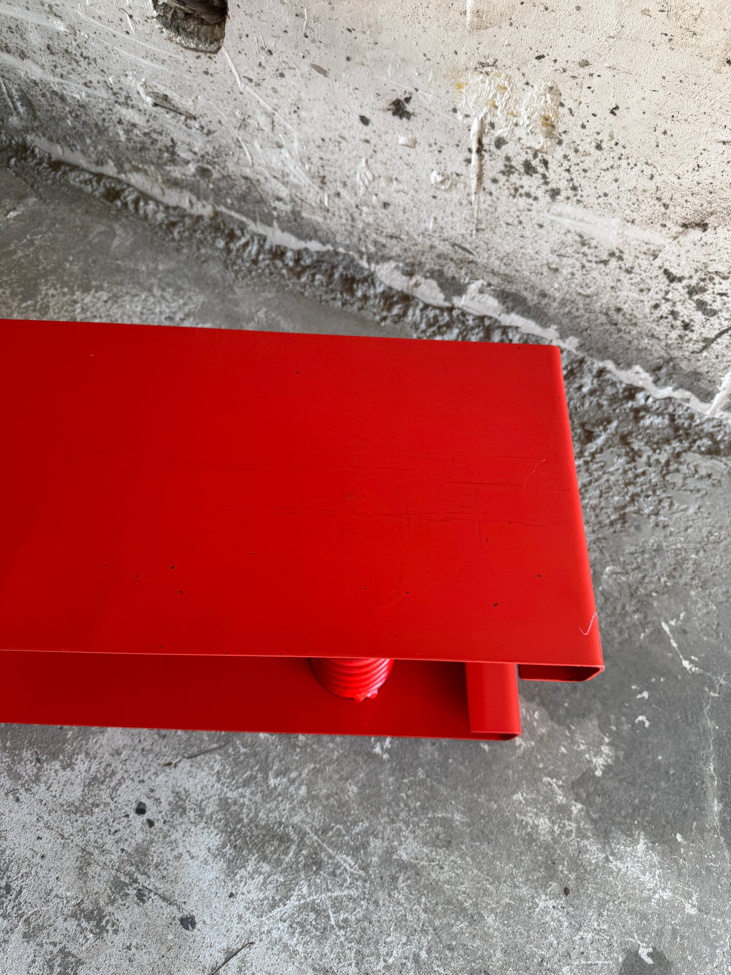 Table basse unique en acier laqué rouge avec ressort