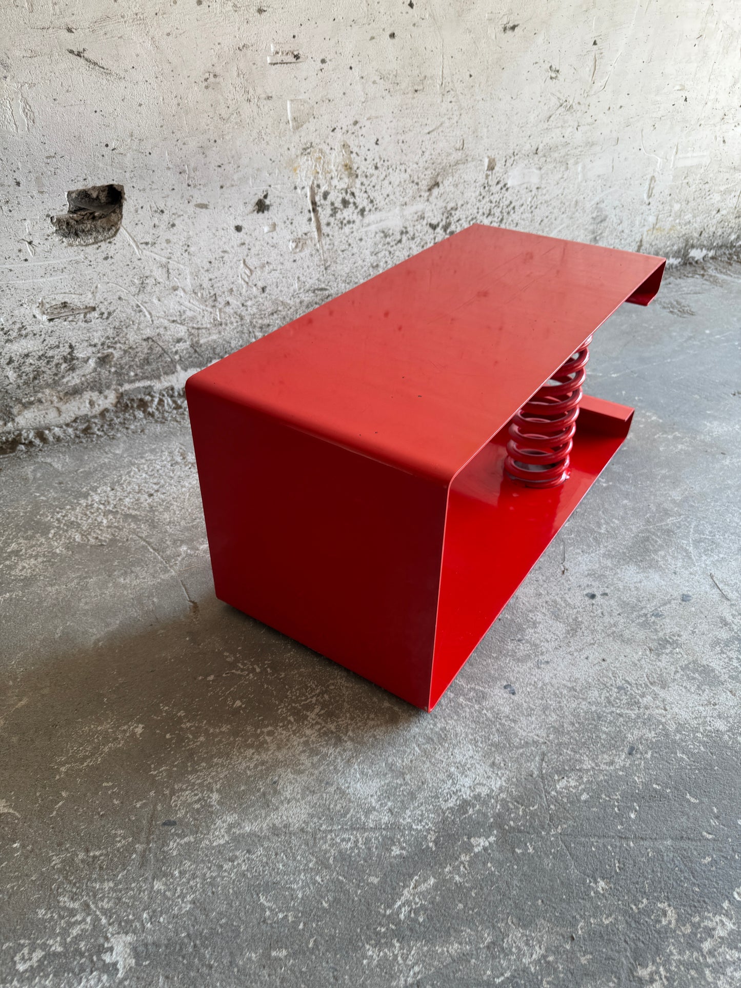 Table basse unique en acier laqué rouge avec ressort