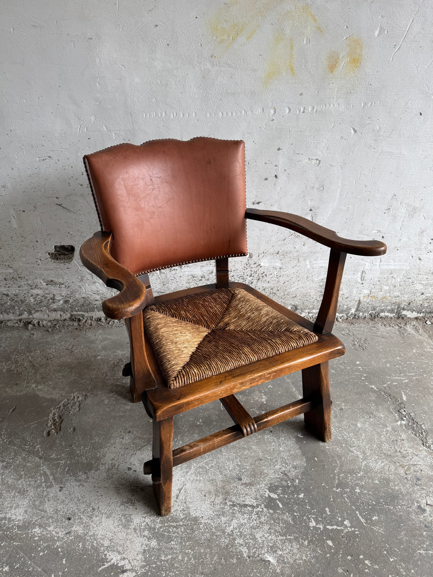 Brutalist armchair with rattan seat and leather back