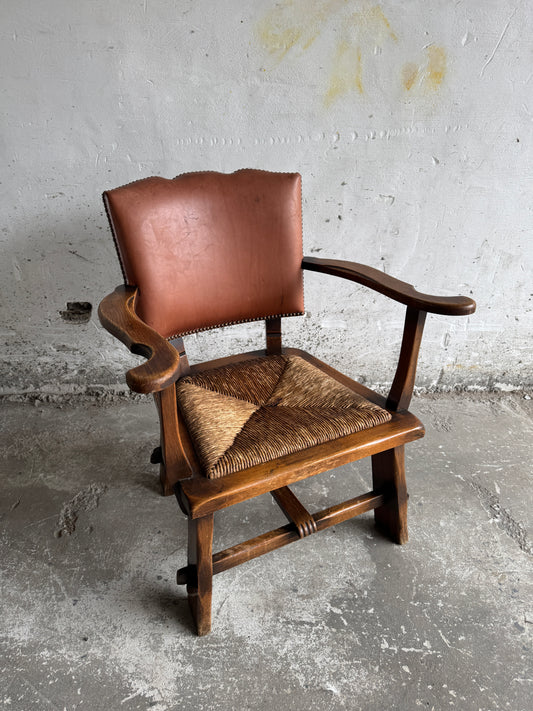 Brutalistische fauteuil met rotan zitting en leren rugleuning