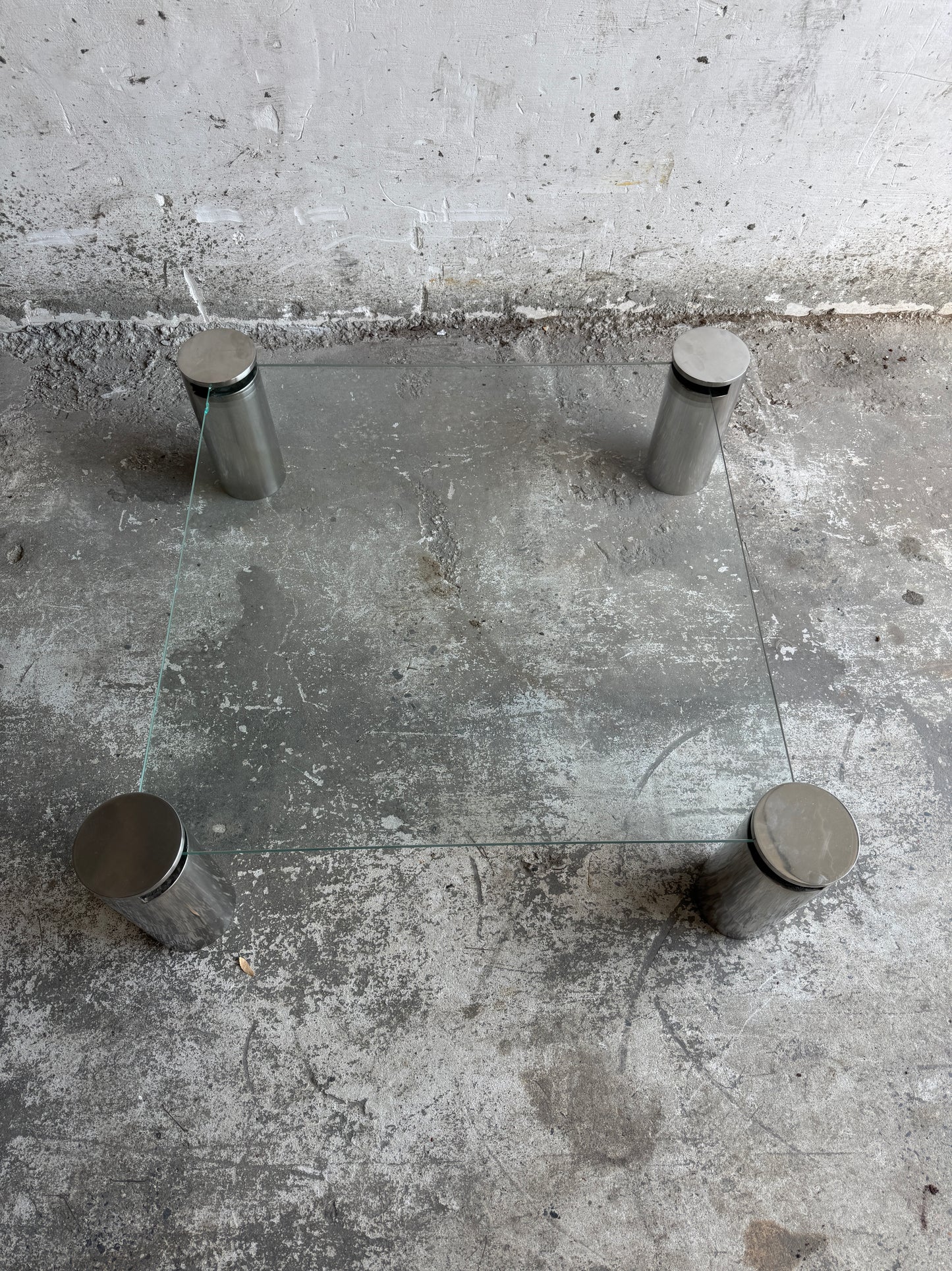 Modernistische vierkante salontafel met glazen blad en stalen cilinderpoten