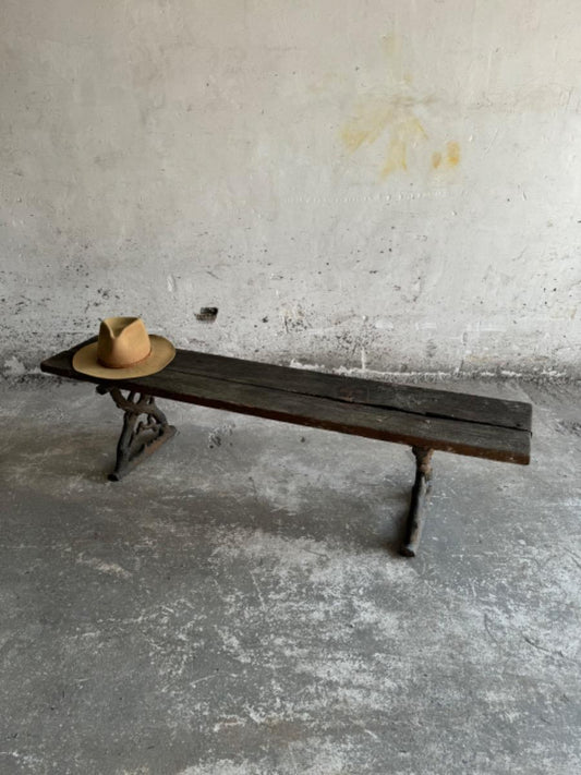 Antieke tuinbank met gietijzeren poten en verweerde houten zitting