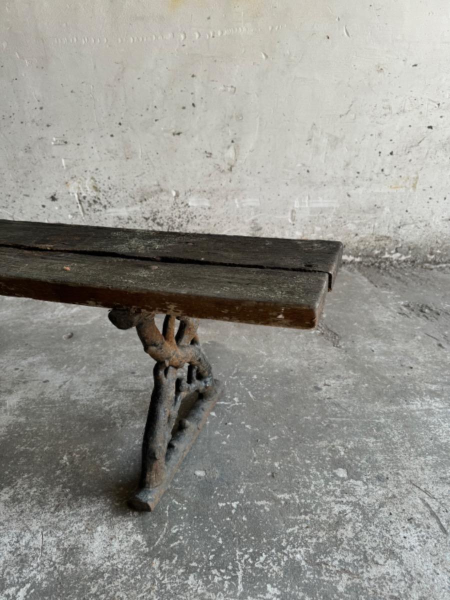 Banc de jardin ancien avec pieds en fonte et assise en bois patiné