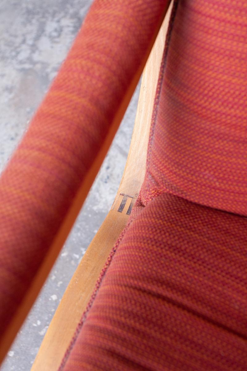 Pair of red fabric and wooden club chairs with soft lined design.