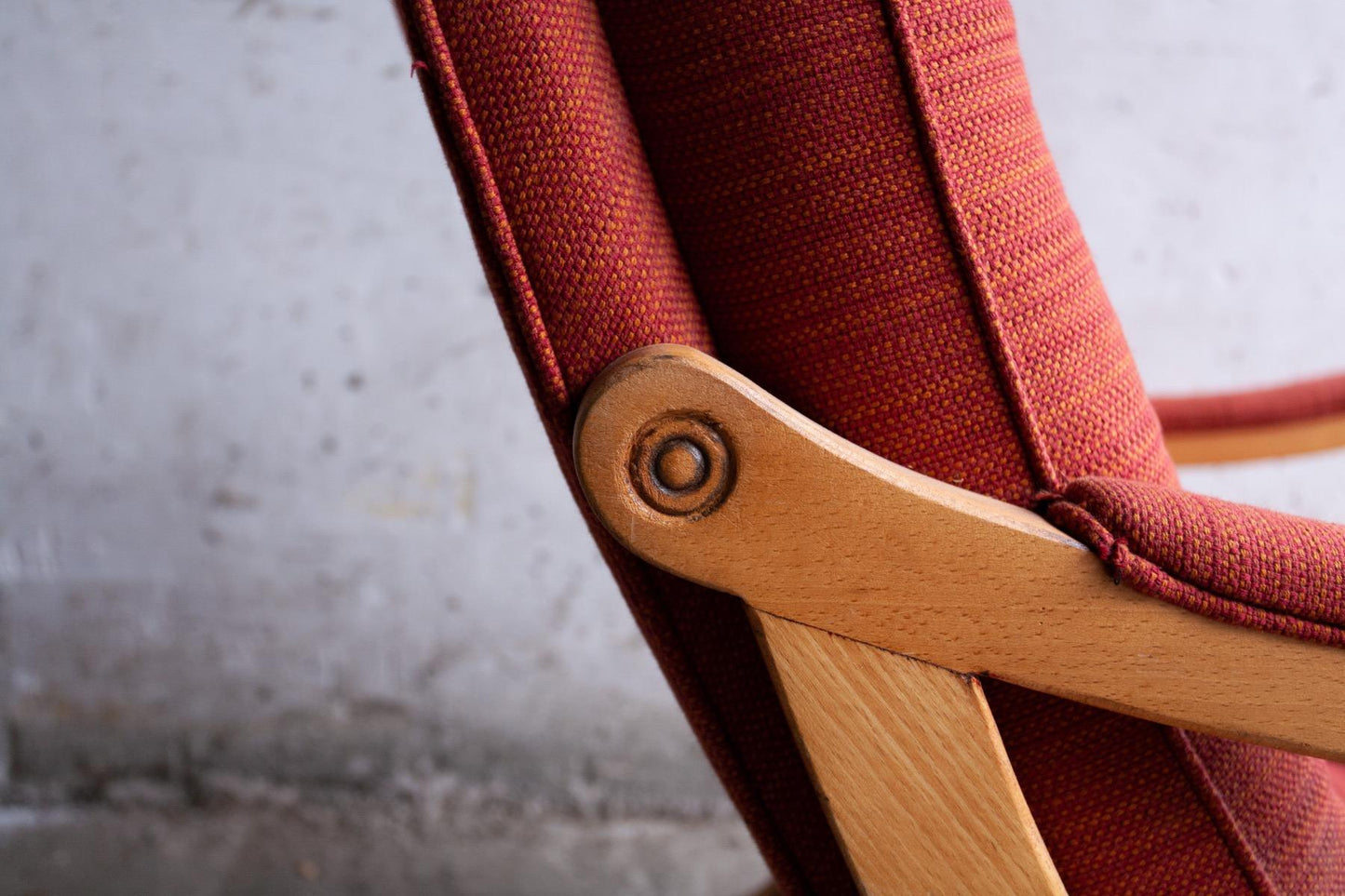 Pair of red fabric and wooden club chairs with soft lined design.