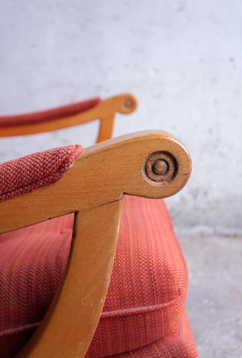 Pair of red fabric and wooden club chairs with soft lined design.