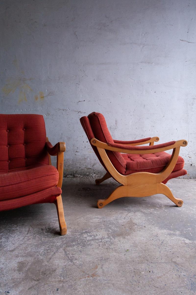 Pair of red fabric and wooden club chairs with soft lined design.