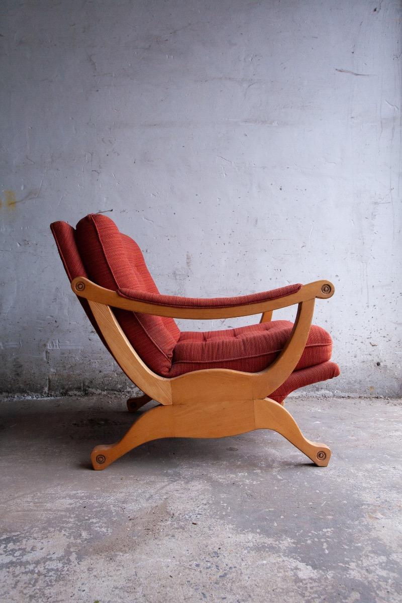 Pair of red fabric and wooden club chairs with soft lined design.