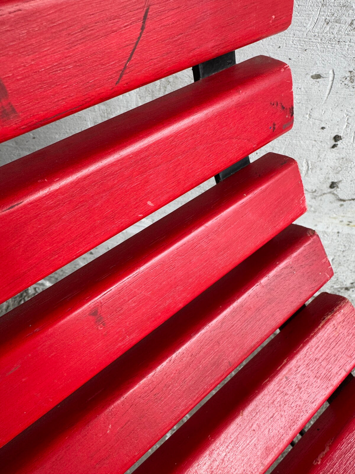 Rode lattenstoel met zwart metalen frame